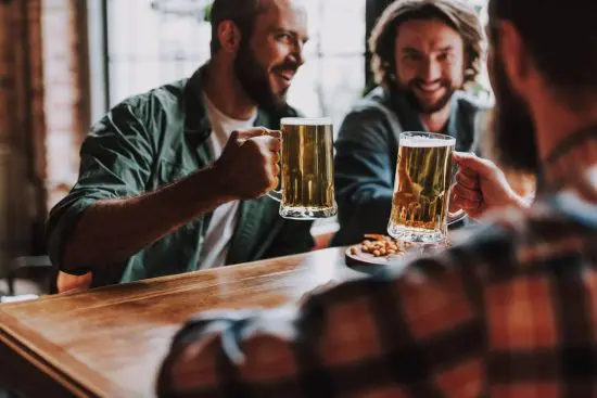 Three men drinking beer from mugs