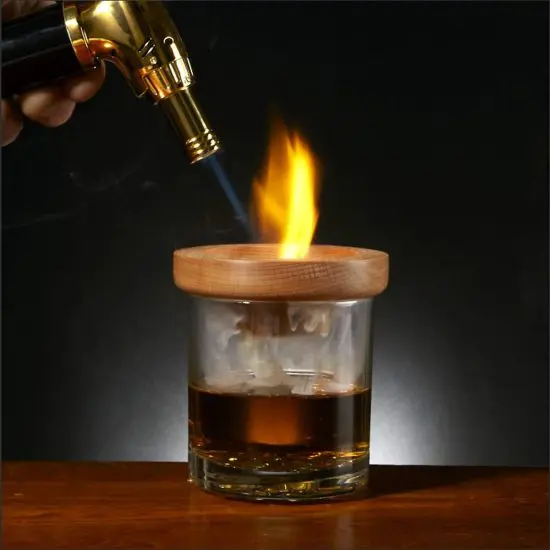Cocktail torch flaming a glass of whiskey