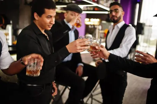 Well dressed men drinking bourbon