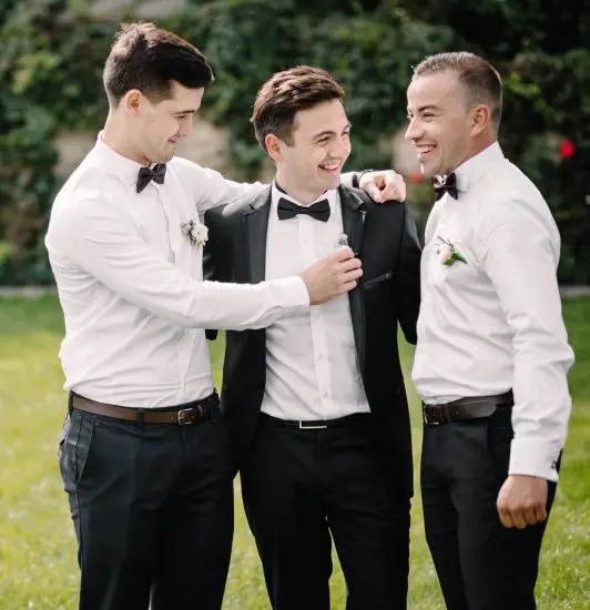 Groom with two groomsman laughing together