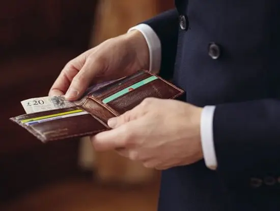 Man in suit holding a Vittore leather wallet