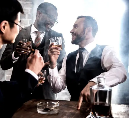 Men toasting with twist bourbon glasses