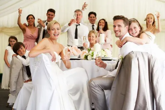 People celebrating with wedding reception gifts and champagne flutes