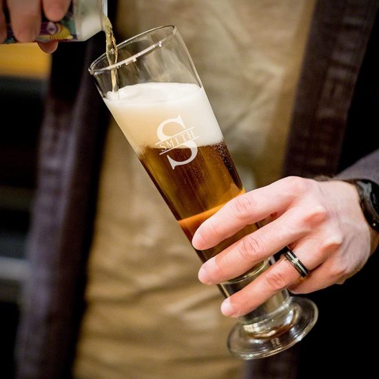 man pouring a pilsner glass