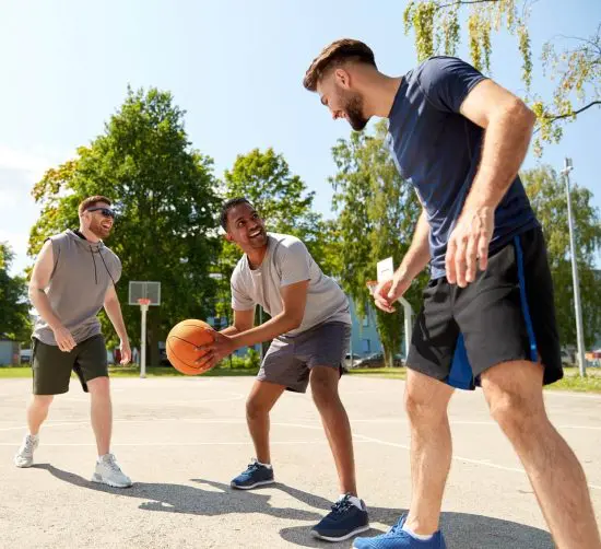 Three men playing basketball outside