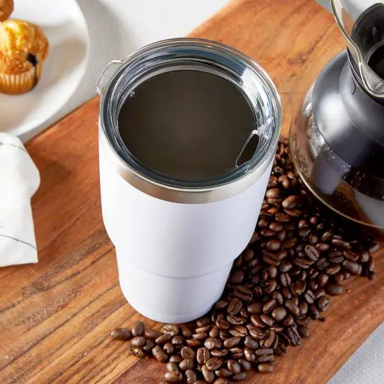 Custom white coffee tumbler seen from above with coffee beans