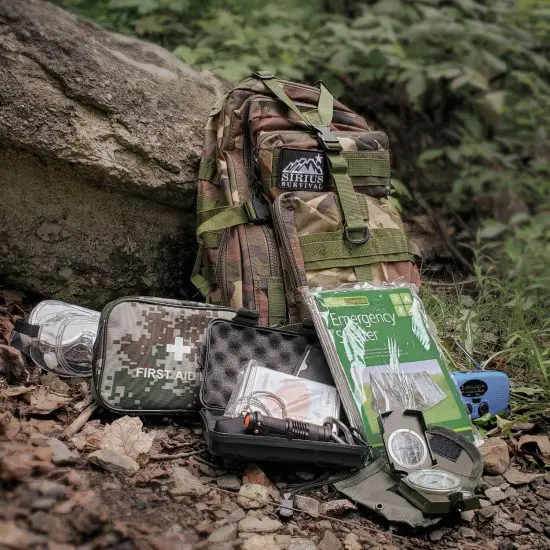 Wilderness survival backpack kit leaning on a tree