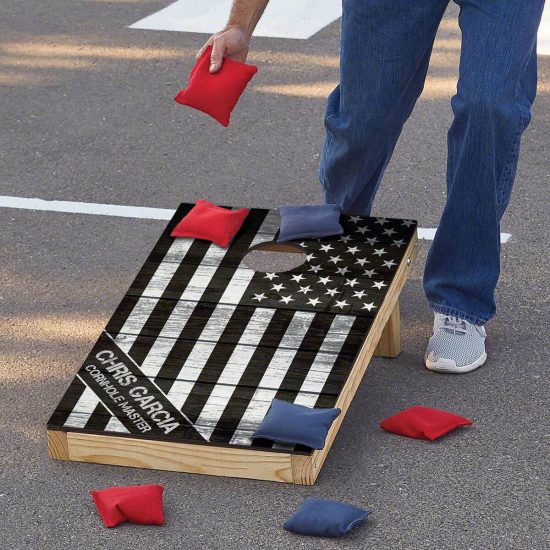 Man picking up bean bags from military retirement gift cornhole set