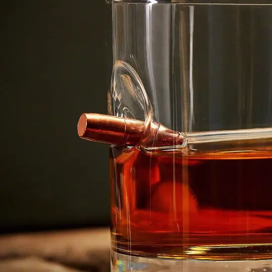 Bullet inside a glass of whiskey