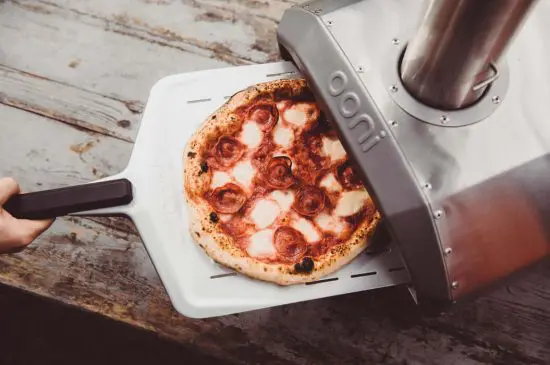Cooking pizza outdoors with portable pizza oven