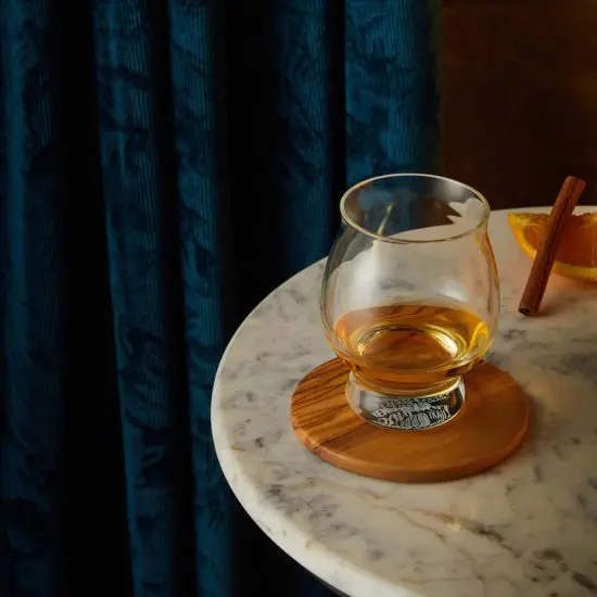 Kentucky bourbon trail whiskey glass on table near cinnamon
