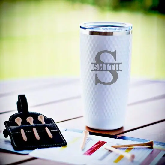 Coffee tumbler and other golf accessories on outdoor table