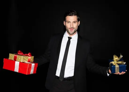 Man in suit holding multiple cheap gifts for men
