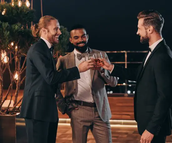 Happy men in suits having a whiskey toast