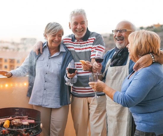 Happy group of old people having barbecue and wine
