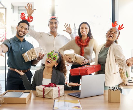 Cheerful group of employees with Christmas presents
