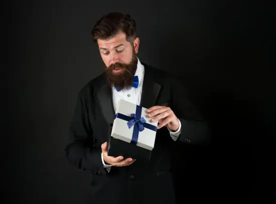 Man in Suit Looking Surprised While Holding Gift
