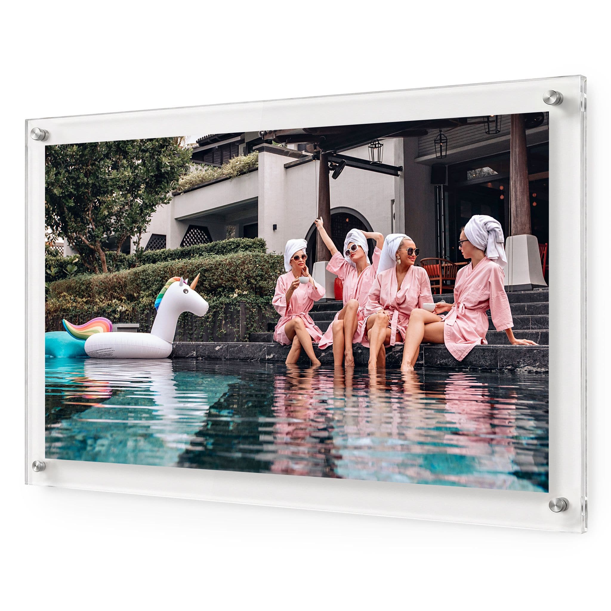 Acrylic wall art featuring women in pink robes relaxing by a pool