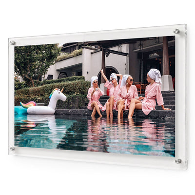 Acrylic wall art featuring women in pink robes relaxing by a pool