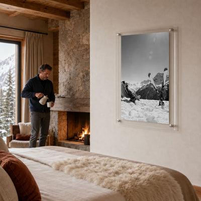 Black and white ski wall art displayed in a cozy modern bedroom bed with man standing