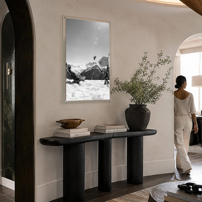 Black and white ski wall art in a bright and modern entryway with woman aside