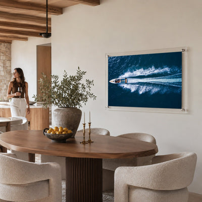 Exit By Sea wall art displayed in a bright dining room setting with woman standing