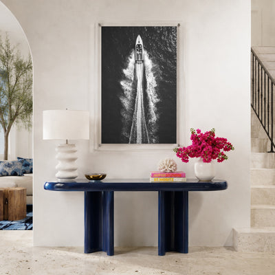 Exit By Sea wall art above a navy console table in a foyer space with stairways aside