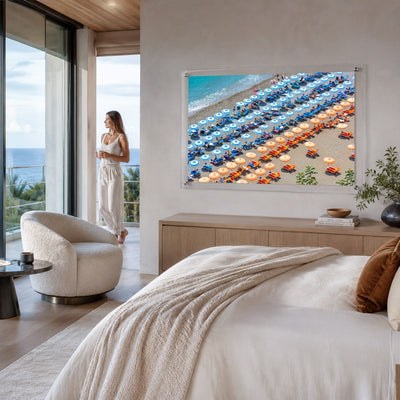 Stripes and Spritz wall art displayed above a bed in a coastal bedroom with woman looking afar