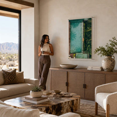 Palm and Circumstance wall art in a bright modern living room with woman aside