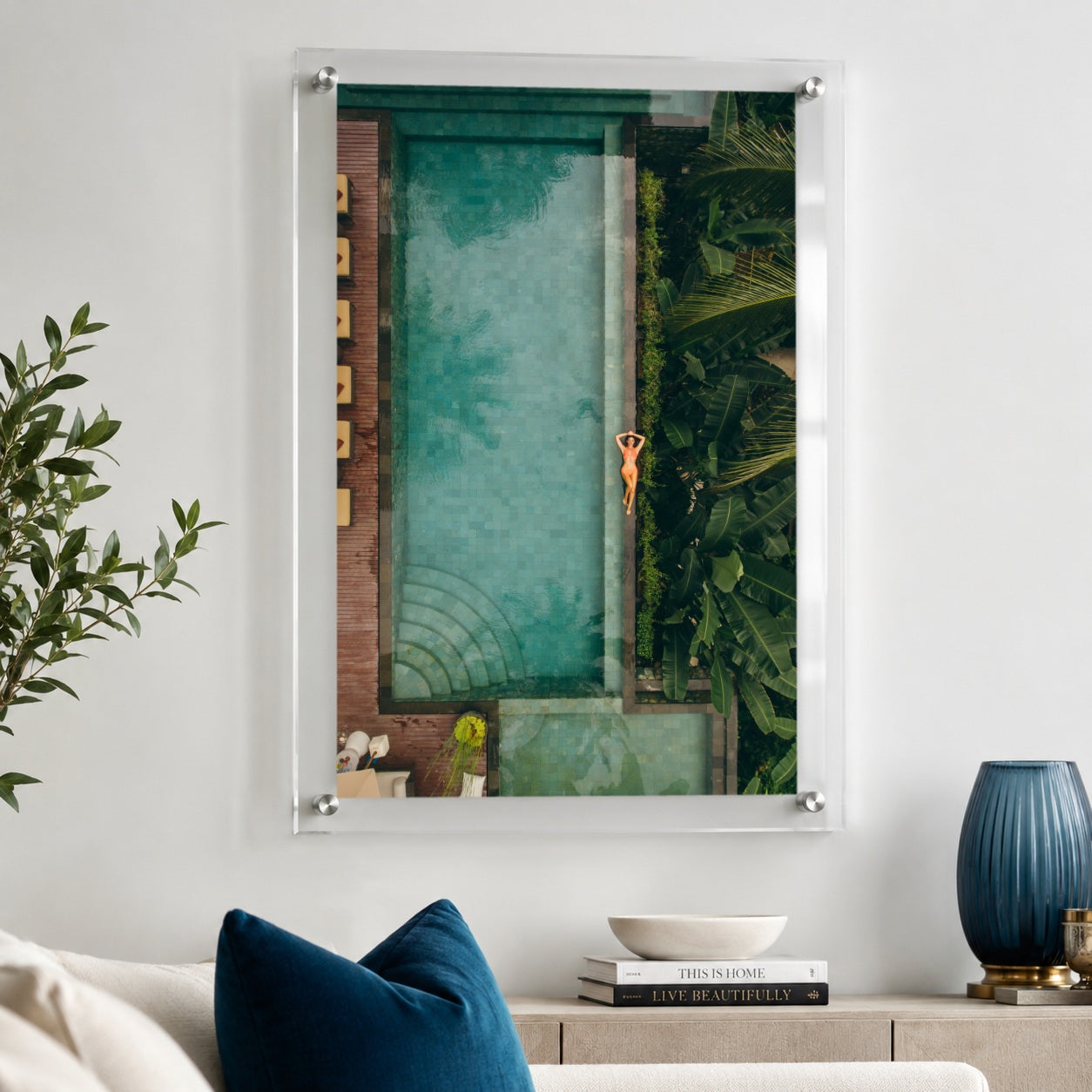 Palm and Circumstance wall art displayed above a sofa with blue pillows