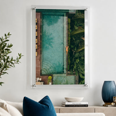 Palm and Circumstance wall art displayed above a sofa with blue pillows