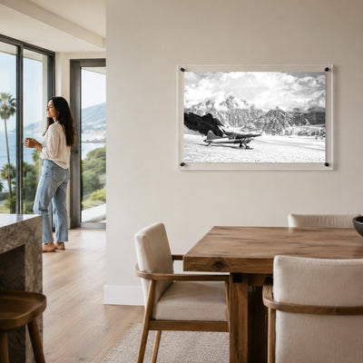 Where Adventure Begins acrylic wall art in a bright dining room with woman standing