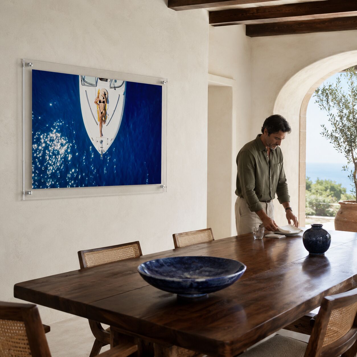 Sun Deck Society wall art in a dining room with a man standing nearby