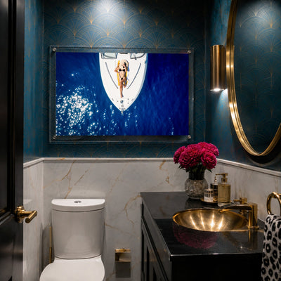 Sun Deck Society wall art displayed inside a moody art deco powder room