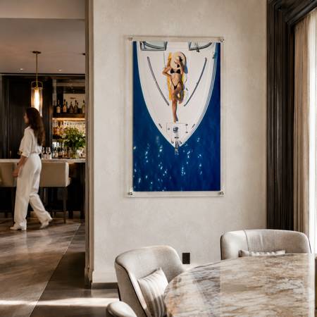 Sun Deck Society wall art hung inside a dining room with a passing woman
