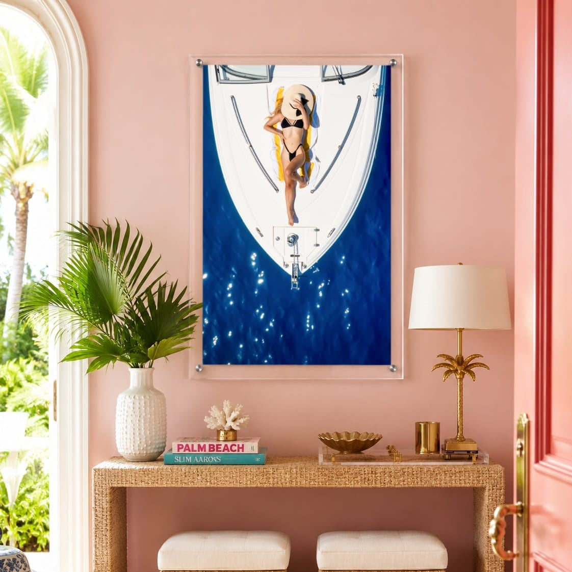 Sun Deck Society wall art hung above a pink entryway with rattan console