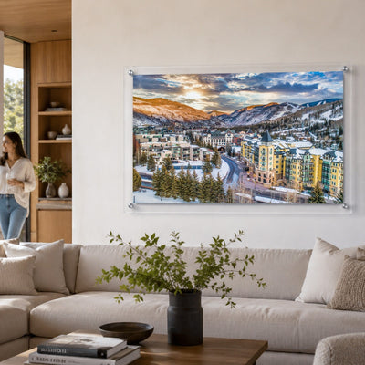 Vail We Meet Again wall art above a bright living room couch with a woman