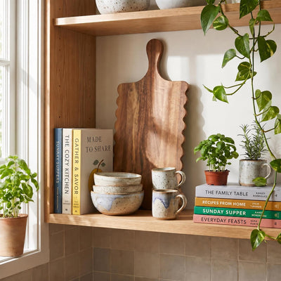 Scalloped acacia serving board arranged as kitchen shelf decor