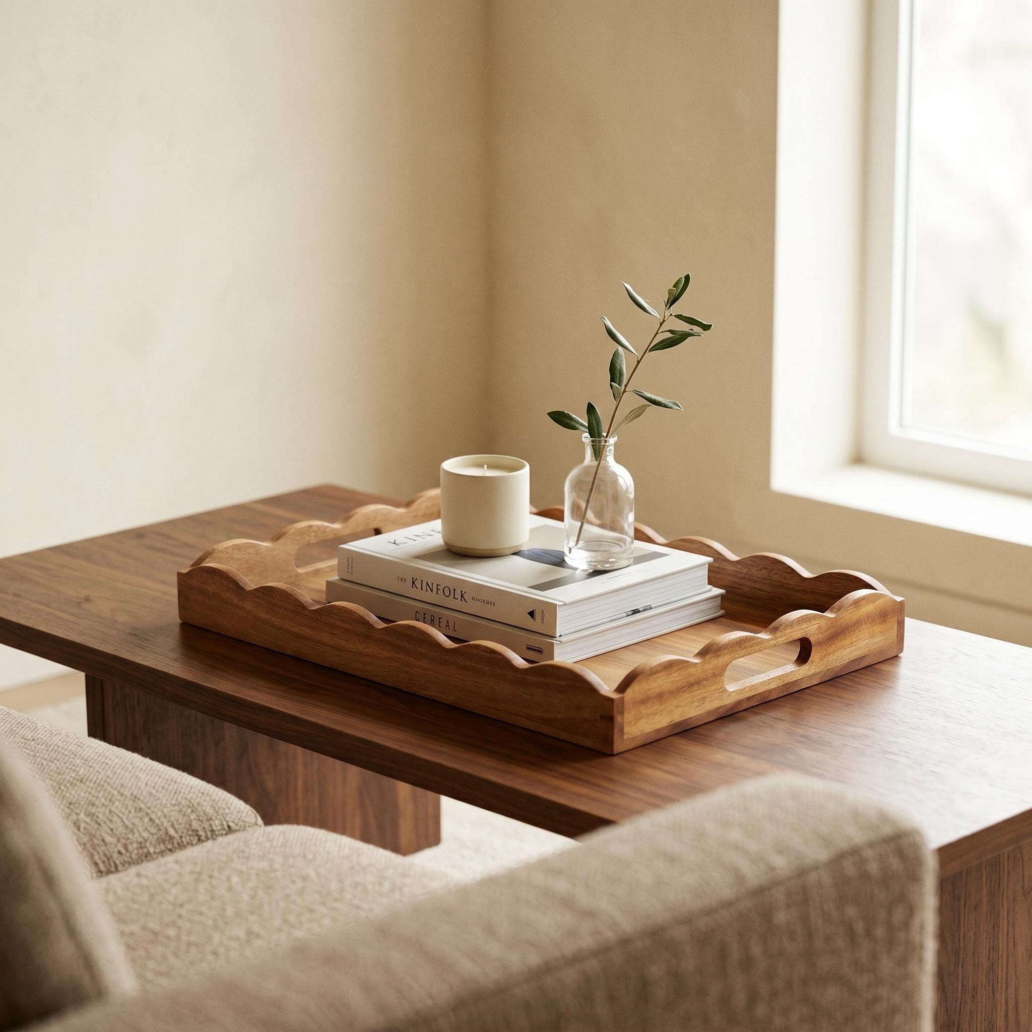Acacia wood scalloped serving tray styled on a living room coffee table