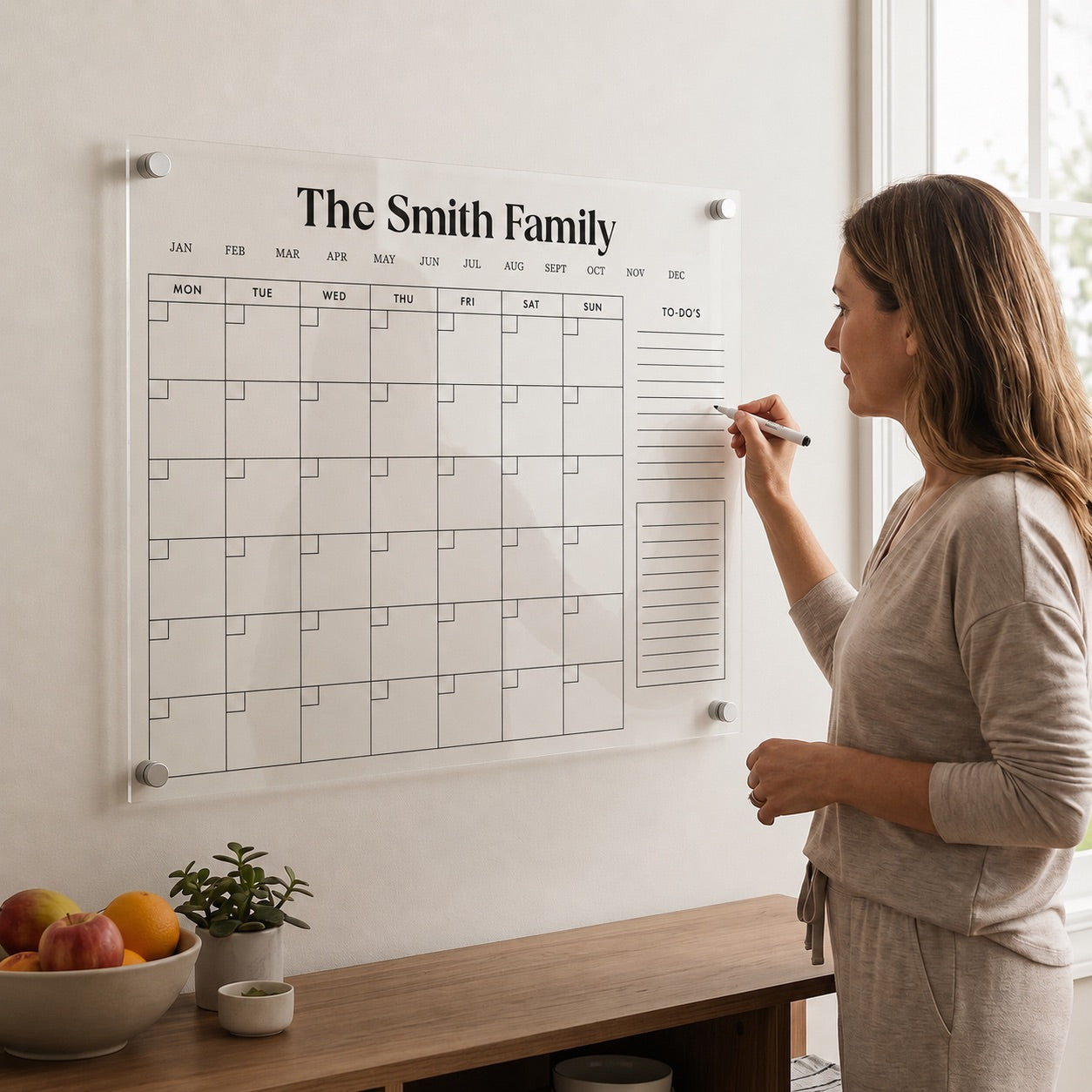 Woman writing on a personalized acrylic family wall calendar