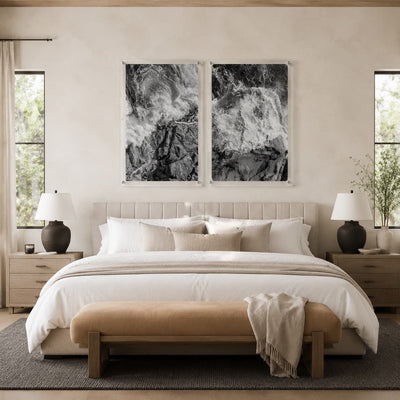 Two black and white ocean wave acrylic wall art pieces in a bedroom
