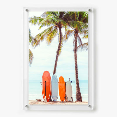 Acrylic wall art featuring colorful surfboards standing beneath tall palm trees on a tropical beach