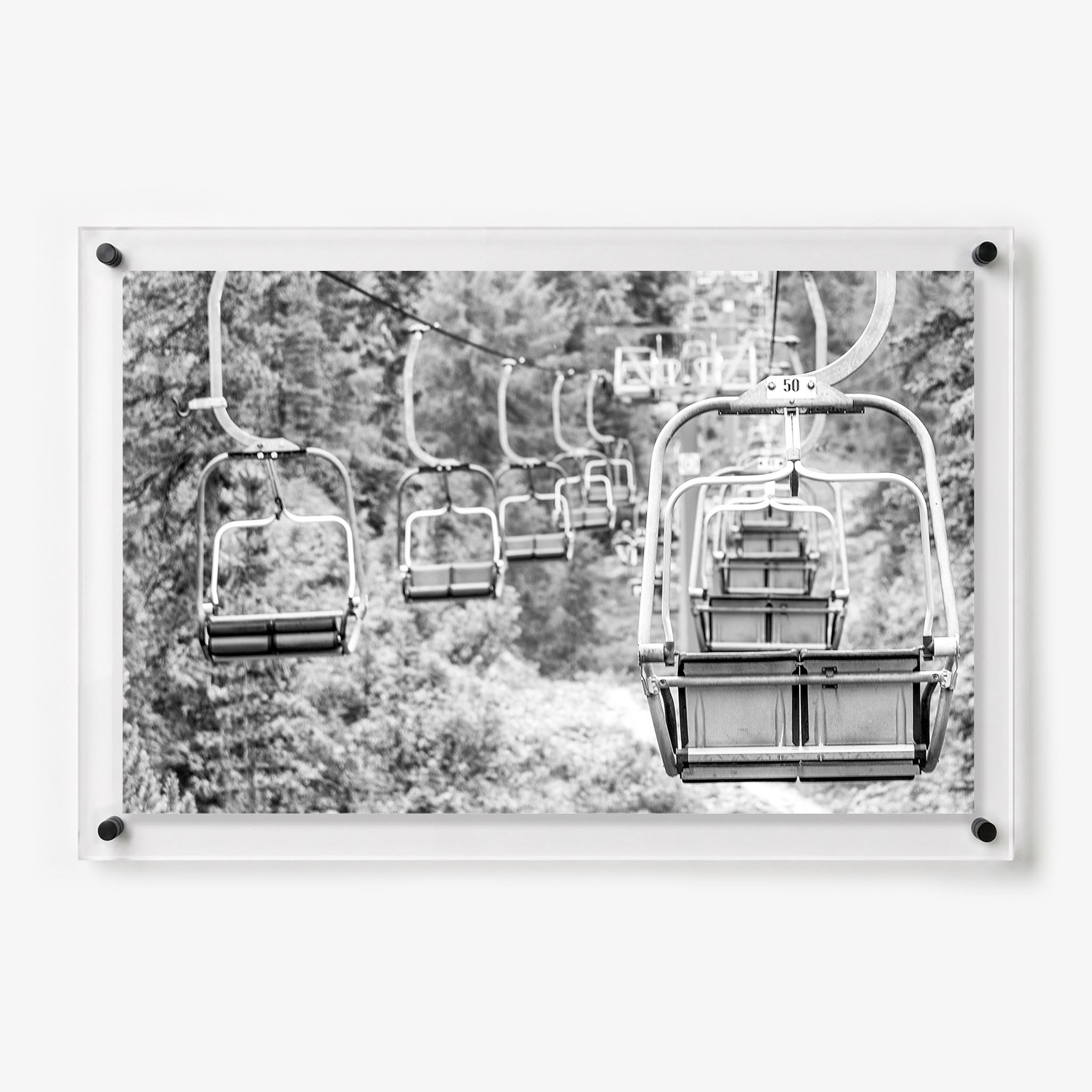 Black and white acrylic wall art featuring empty ski lift chairs 