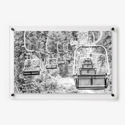 Black and white acrylic wall art featuring empty ski lift chairs 