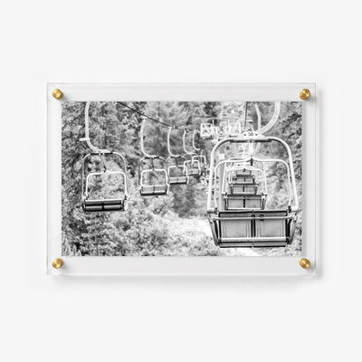 Scenic ski lift chairs suspended over a mountain trail