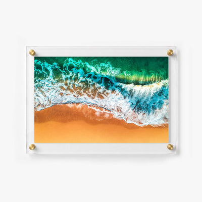 Overhead ocean wall art featuring a breaking wave along a vibrant sandy beach