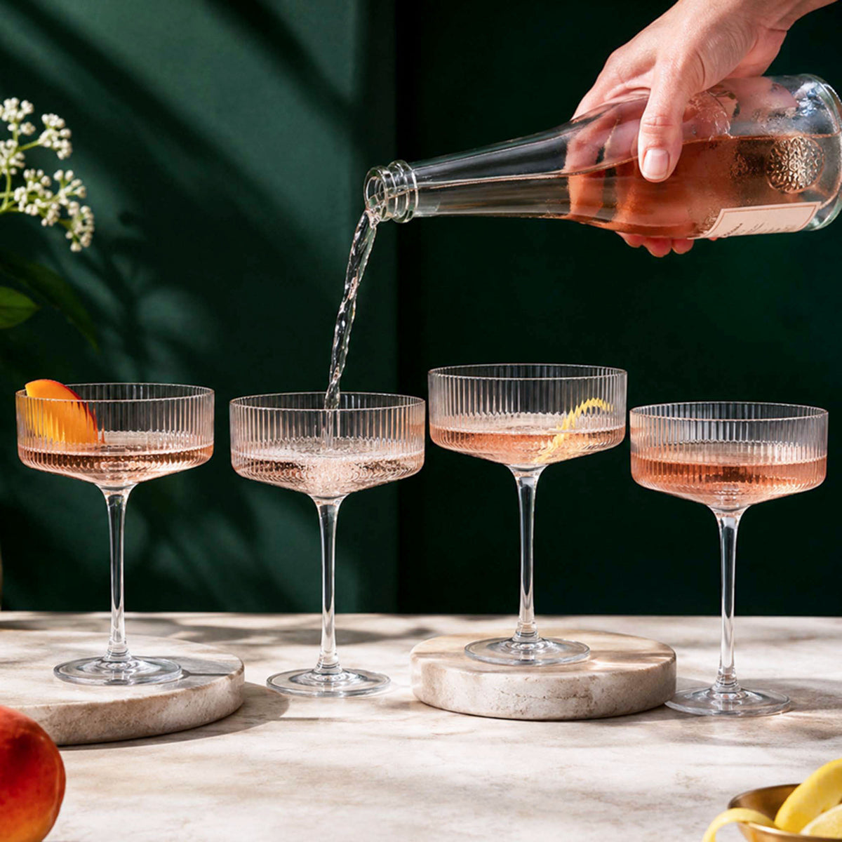 champagne coupe glasses with sparkling rosé being poured