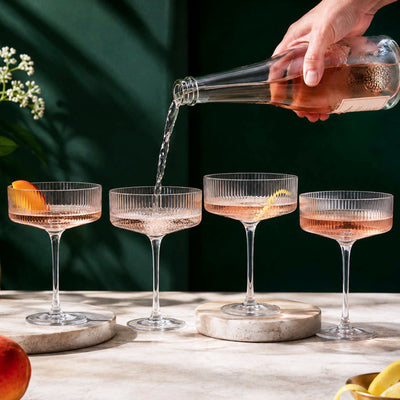 champagne coupe glasses with sparkling rosé being poured