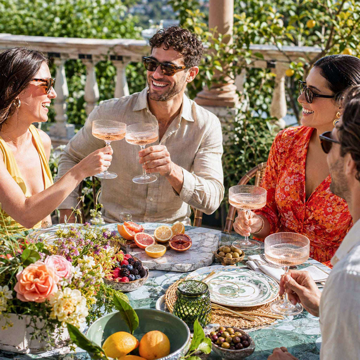 friends enjoying champagne coupe glasses at outdoor gathering