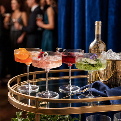 elegant ribbed cocktail coupe glasses on gold bar cart